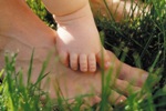 Adult and Baby Feet in Grass